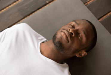 Person practicing deep breathing with eyes closed in a calm setting