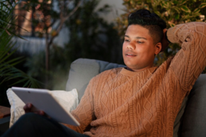 Person casually using a tablet for entertainment in a relaxed evening setting